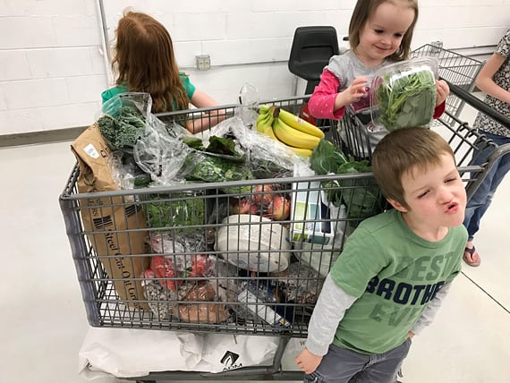 kids in a plant-based family with grocery cart buying vegan groceries